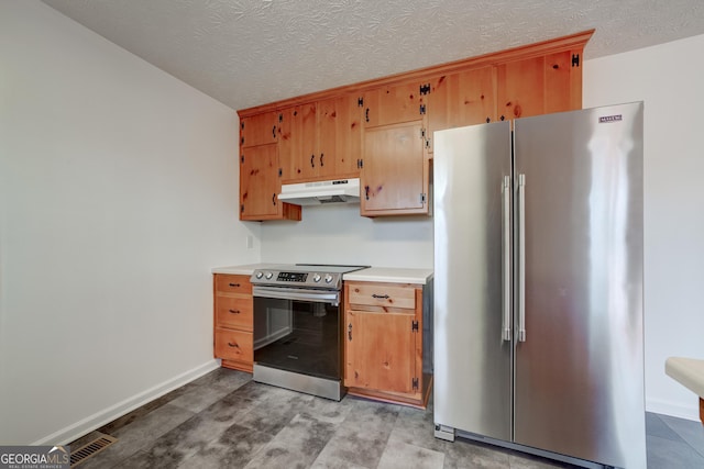 kitchen with under cabinet range hood, a textured ceiling, stainless steel appliances, light countertops, and baseboards