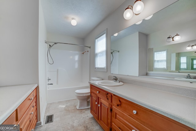 full bath featuring visible vents, toilet, a textured ceiling, shower / washtub combination, and vanity