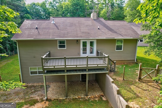 rear view of house with a yard, a deck, and a chimney