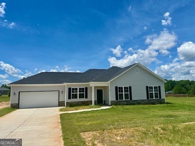 ranch-style home with a garage and a front lawn