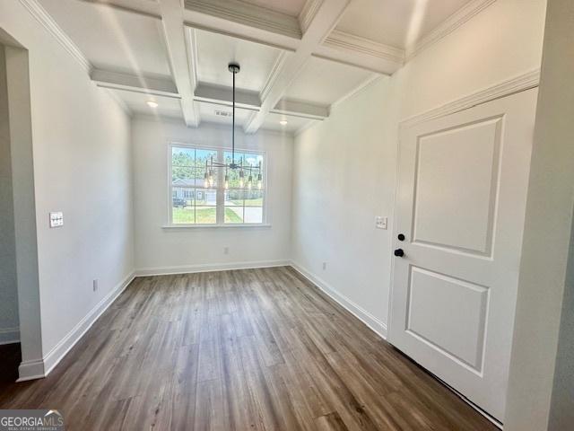 unfurnished dining area featuring coffered ceiling, dark hardwood / wood-style flooring, crown molding, and beamed ceiling