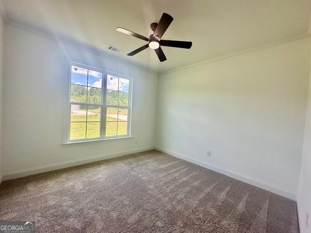 empty room featuring ornamental molding, carpet, and ceiling fan