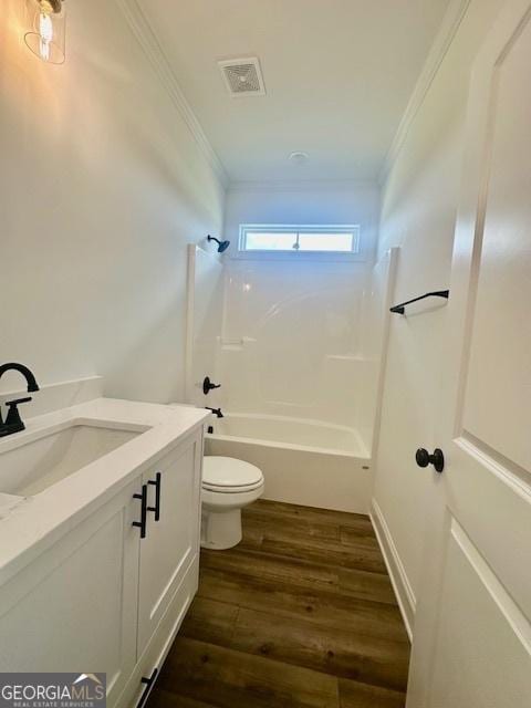 full bathroom with bathing tub / shower combination, hardwood / wood-style flooring, vanity, toilet, and crown molding