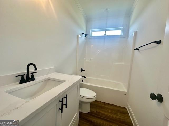 full bathroom featuring bathtub / shower combination, hardwood / wood-style flooring, vanity, toilet, and crown molding