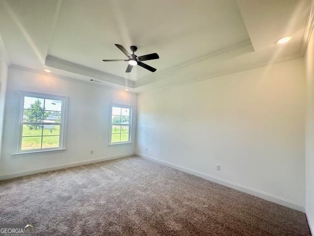 carpeted spare room featuring crown molding, ceiling fan, and a tray ceiling