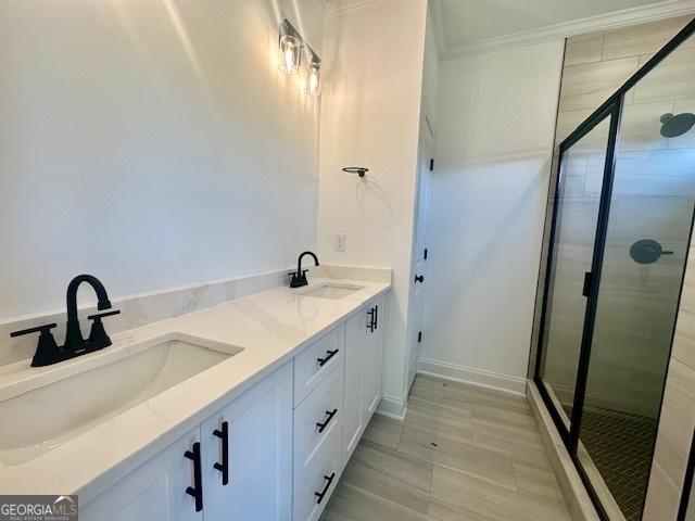 bathroom with crown molding, vanity, and a shower with door