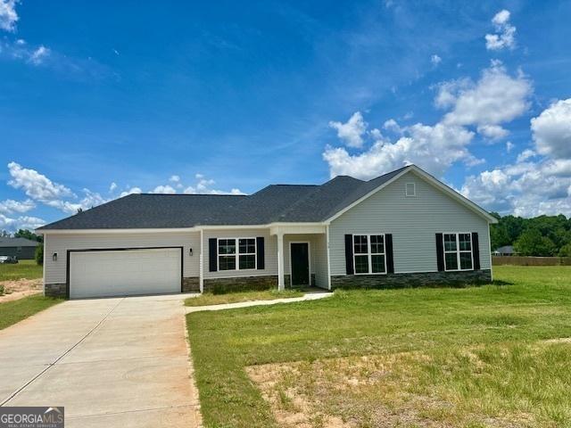 ranch-style home featuring a garage and a front lawn