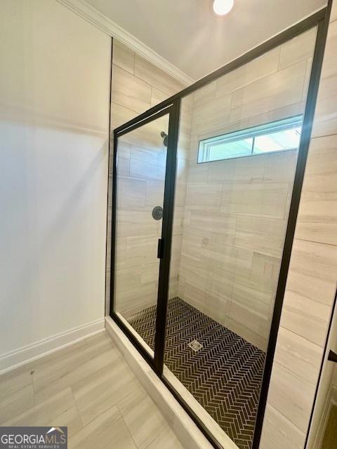 bathroom with walk in shower and crown molding