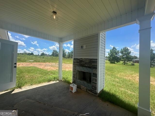 view of patio with an outdoor stone fireplace