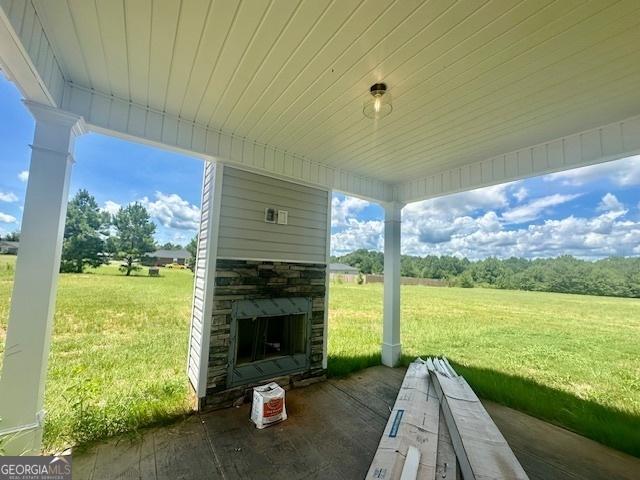 view of patio / terrace featuring an outdoor stone fireplace