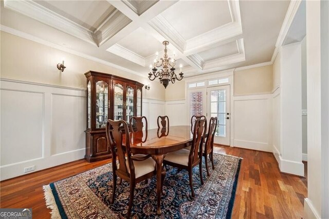 entryway featuring crown molding, light hardwood / wood-style flooring, a chandelier, beamed ceiling, and coffered ceiling