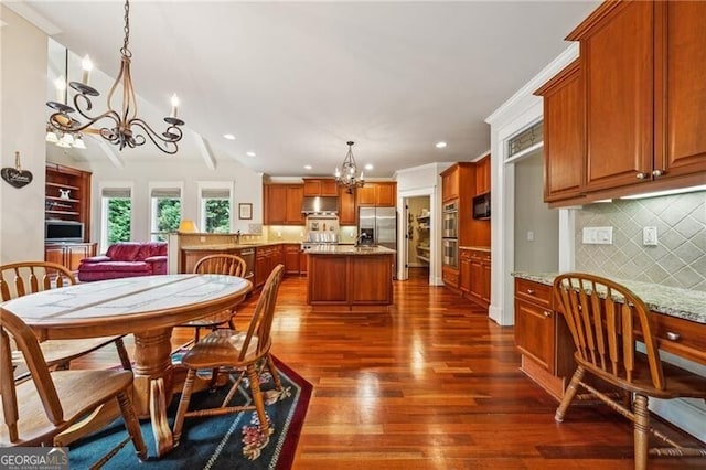 dining space featuring a fireplace, built in shelves, ceiling fan with notable chandelier, and hardwood / wood-style floors