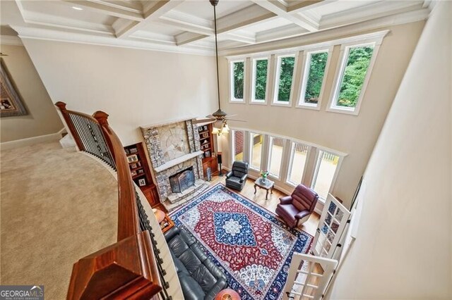 hallway with crown molding, light carpet, beam ceiling, and coffered ceiling