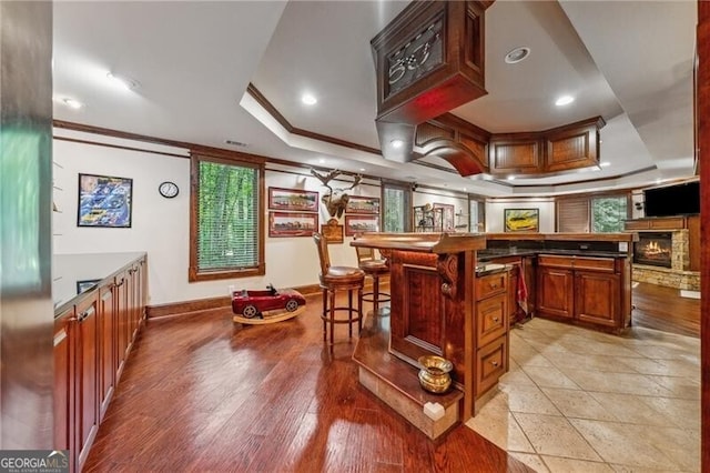 bar with refrigerator, crown molding, a raised ceiling, and dark hardwood / wood-style flooring