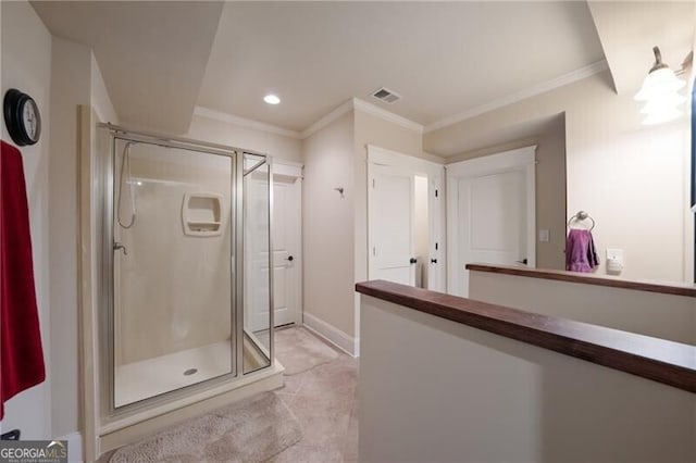 bathroom featuring tile patterned floors, a shower with door, and crown molding