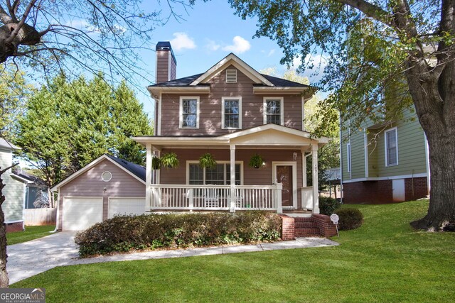 view of front facade featuring covered porch, an outbuilding, a garage, and a front yard