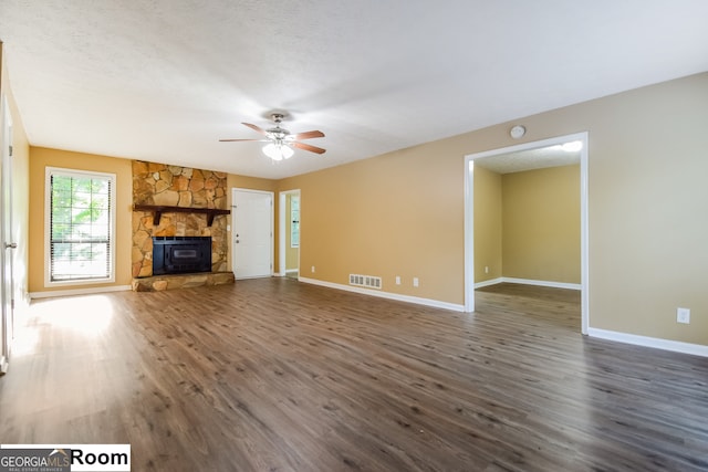 unfurnished living room with dark hardwood / wood-style floors, a fireplace, a textured ceiling, and ceiling fan