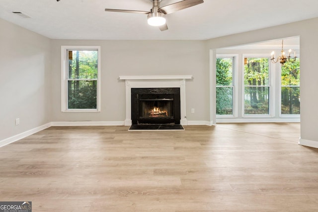 unfurnished living room featuring a fireplace with flush hearth, visible vents, light wood-style flooring, and baseboards