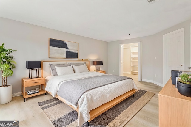 bedroom with light wood-style flooring and baseboards