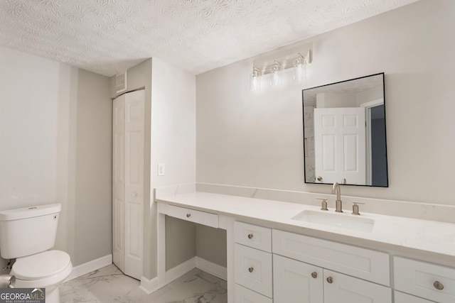 bathroom featuring toilet, vanity, baseboards, marble finish floor, and a closet