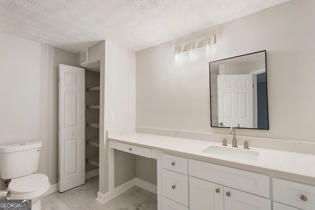 bathroom with toilet, marble finish floor, vanity, and baseboards