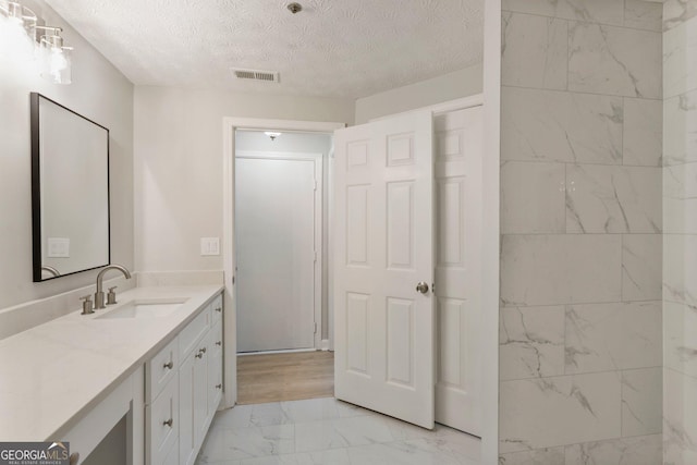 bathroom featuring visible vents, marble finish floor, a textured ceiling, and vanity