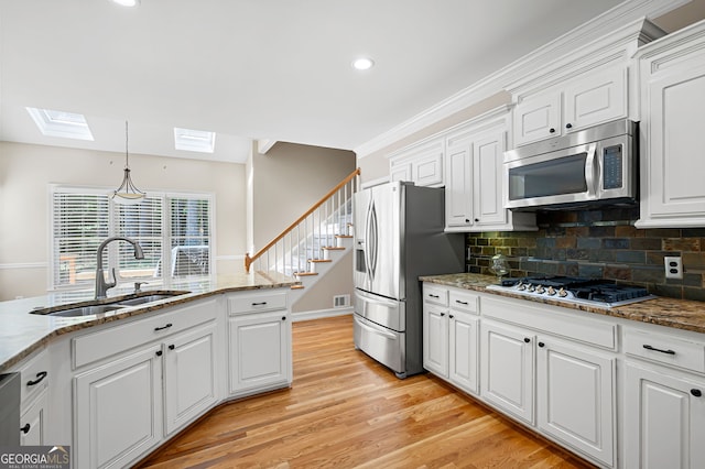 kitchen with light hardwood / wood-style floors, white cabinetry, and stainless steel appliances