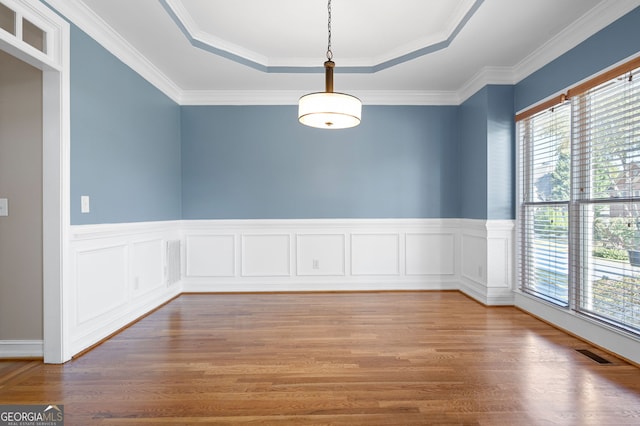 spare room featuring a wealth of natural light, crown molding, hardwood / wood-style flooring, and a tray ceiling