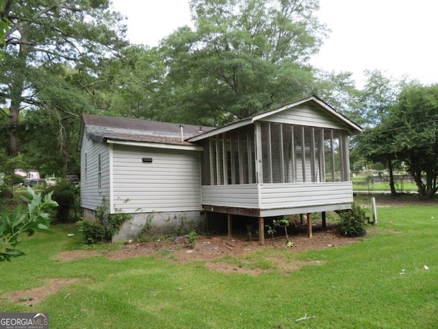 rear view of house with a sunroom and a lawn