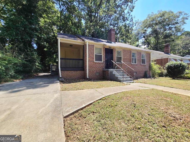 view of front of house featuring a carport and a front yard