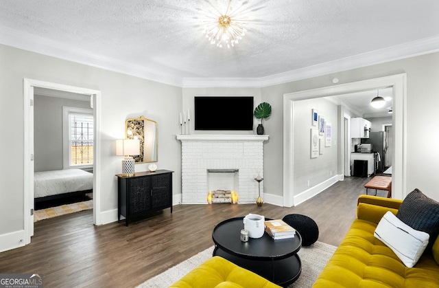 living room with a textured ceiling, dark wood-type flooring, crown molding, and a fireplace