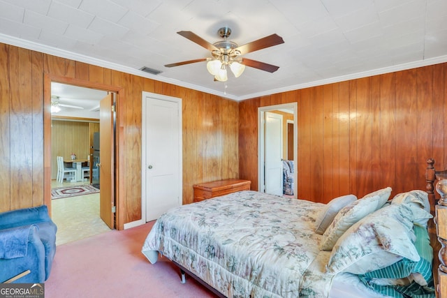 bedroom featuring ceiling fan, light colored carpet, ornamental molding, and wood walls