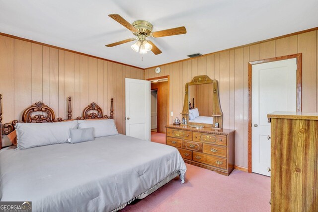 carpeted bedroom featuring ceiling fan, crown molding, and wooden walls