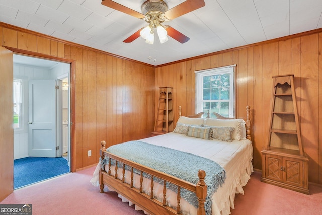 bedroom featuring ceiling fan, crown molding, light carpet, and wooden walls