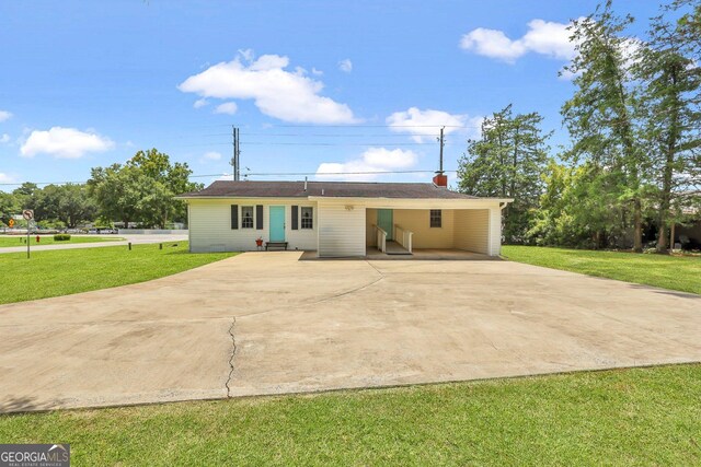 rear view of house featuring a yard and a carport