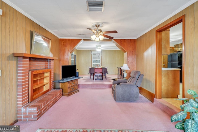 carpeted living room with ceiling fan, a brick fireplace, and ornamental molding