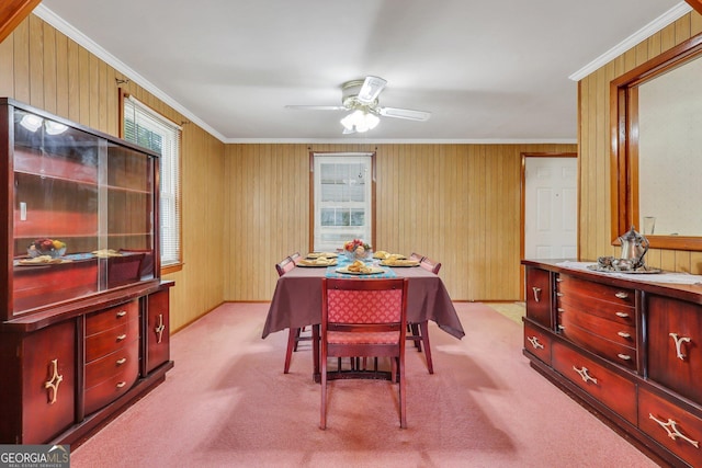 dining area with light colored carpet, crown molding, and wooden walls