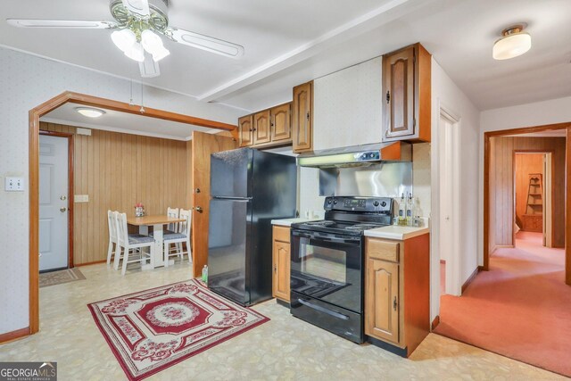 kitchen featuring black appliances, wooden walls, and ceiling fan