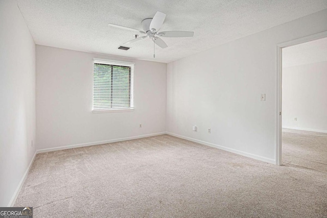 unfurnished room with ceiling fan, light colored carpet, and a textured ceiling