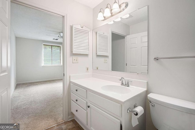 bathroom featuring vanity, a textured ceiling, and toilet