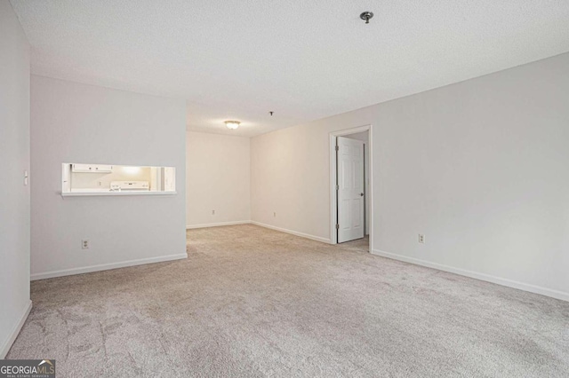 carpeted empty room with a textured ceiling