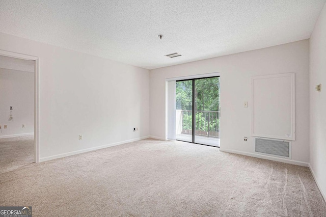 unfurnished room featuring light carpet and a textured ceiling