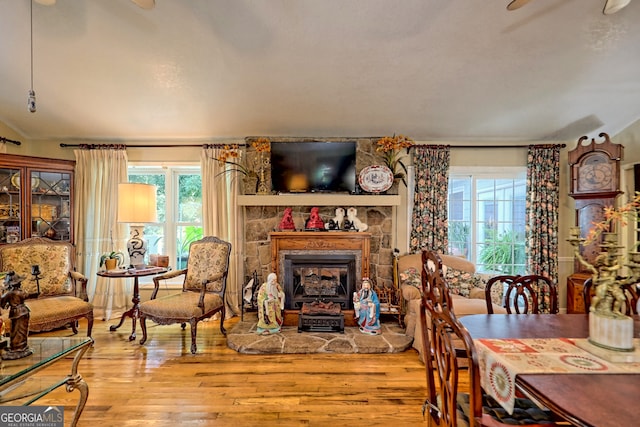 dining space with a stone fireplace and light hardwood / wood-style flooring