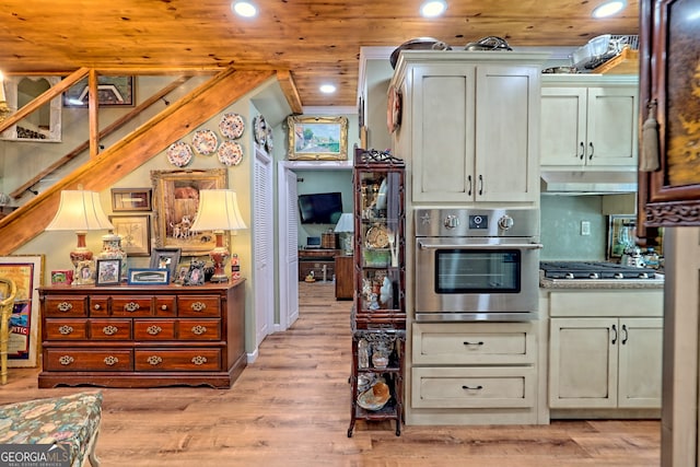 kitchen featuring appliances with stainless steel finishes, light wood-type flooring, and wooden ceiling