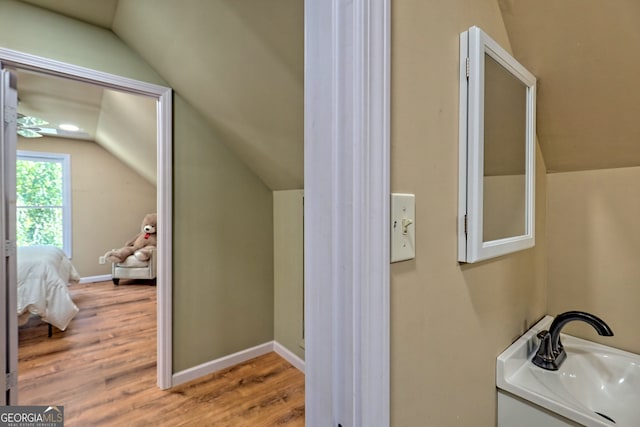 bathroom featuring vanity, lofted ceiling, and hardwood / wood-style floors