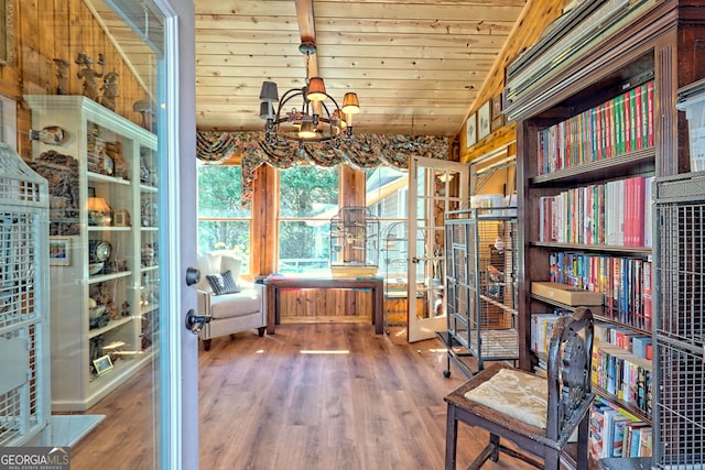 interior space featuring a chandelier, wood walls, wood ceiling, wood-type flooring, and vaulted ceiling