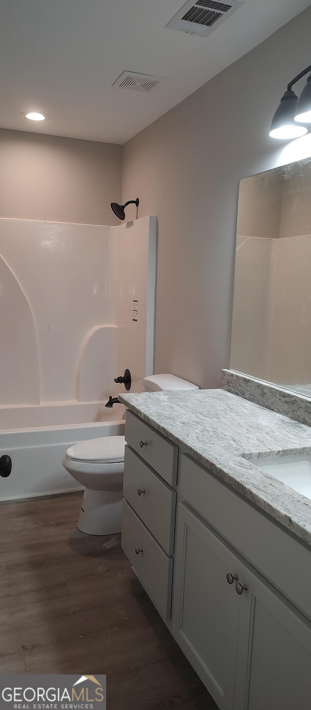 full bathroom with vanity, shower / bathtub combination, toilet, and wood-type flooring