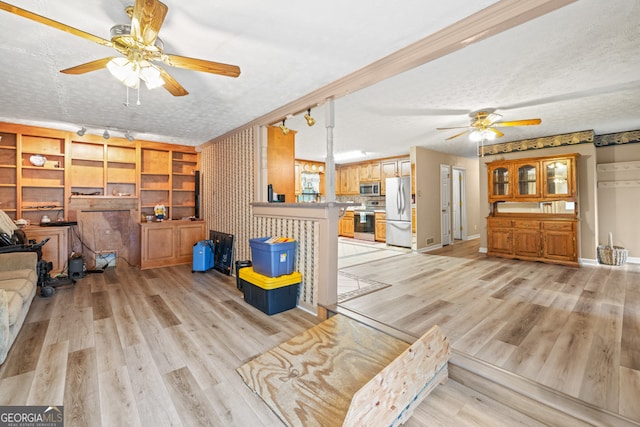 living room featuring ceiling fan, a textured ceiling, light hardwood / wood-style floors, and track lighting