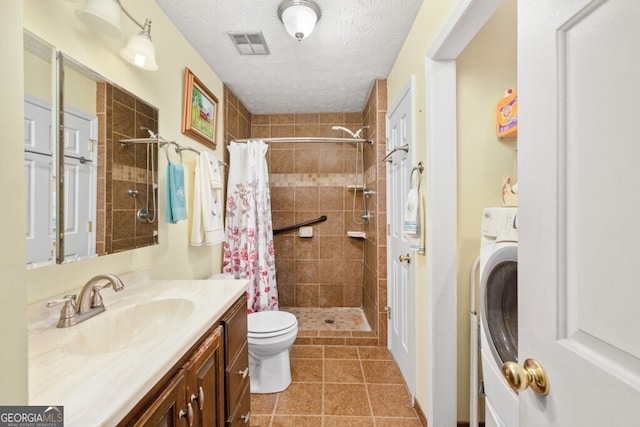 bathroom with washer / clothes dryer, a textured ceiling, a shower with shower curtain, vanity, and toilet