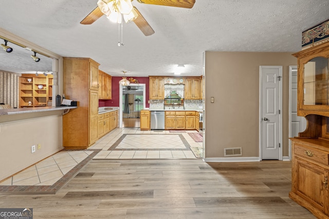 kitchen with backsplash, a textured ceiling, ceiling fan, light hardwood / wood-style flooring, and stainless steel dishwasher